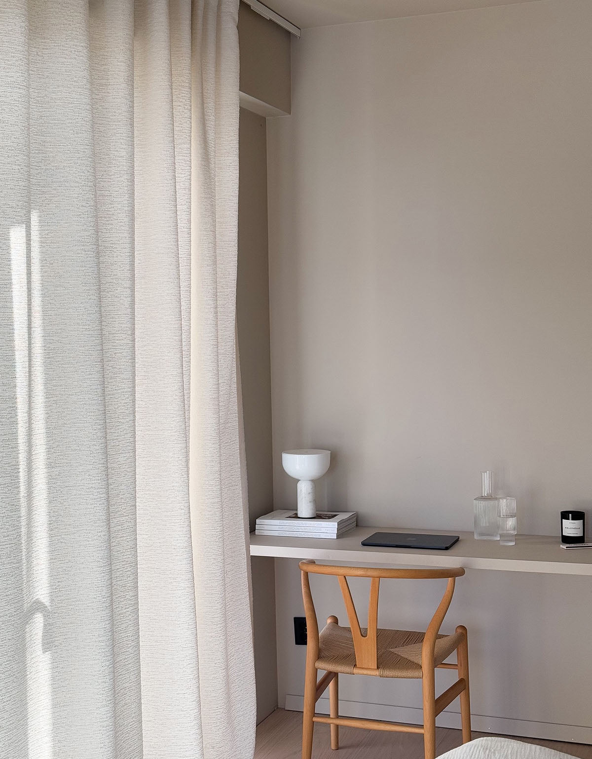 Hemmakontor med ett skrivbord och en stor gardin i vit bouclé