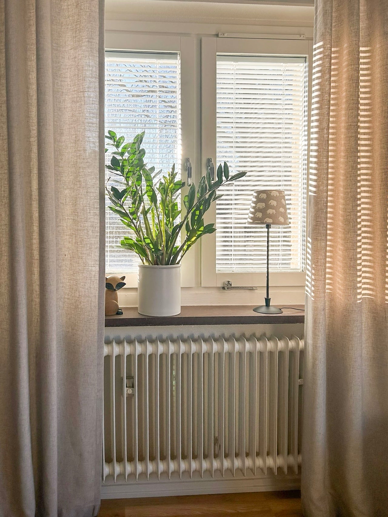 Mellanglaspersienn i vitt i soligt fönster