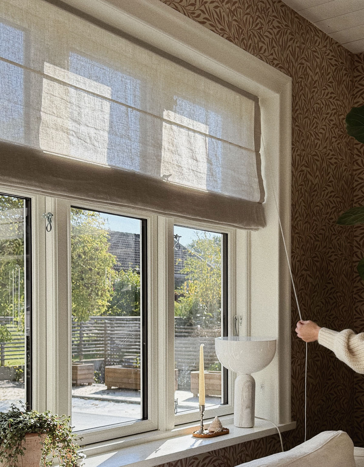 Beige hissgardin i lantligt fönster
